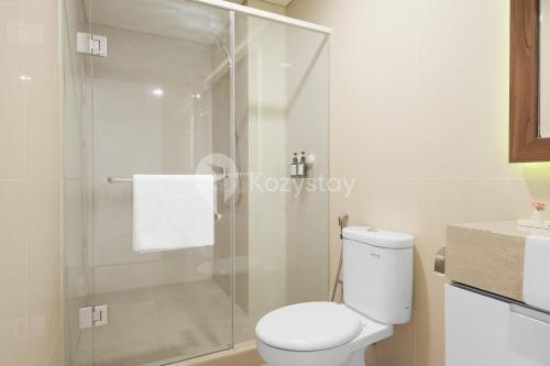 a bathroom with a toilet and a glass shower at Bhumi by Kozystay - Paskal in Bandung