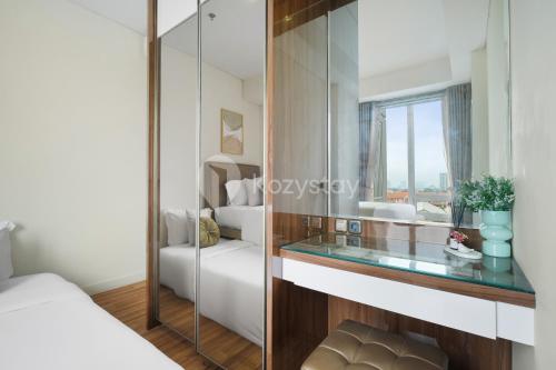 a glass counter in a bedroom with a bed and a window at Bhumi by Kozystay - Paskal in Bandung