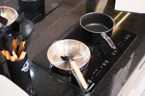 a stove top with pots and pans on it at Bhumi by Kozystay - Paskal in Bandung
