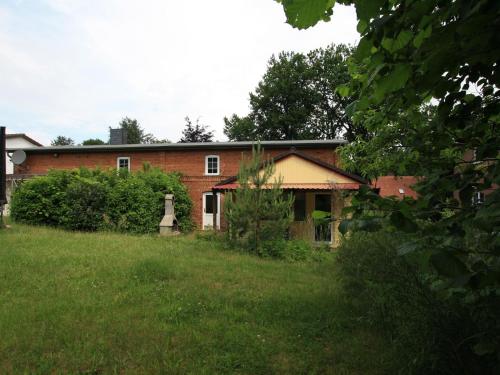 an old brick house in a field of grass at Ferienhaus in Petersdorf mit schönem Garten in Funfseen