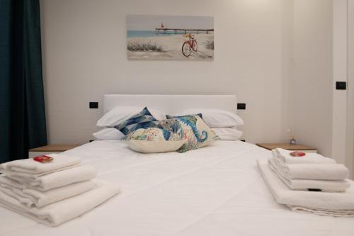 a bedroom with a white bed with towels on it at Da Zia Gina Locazione Turistica in Bisceglie
