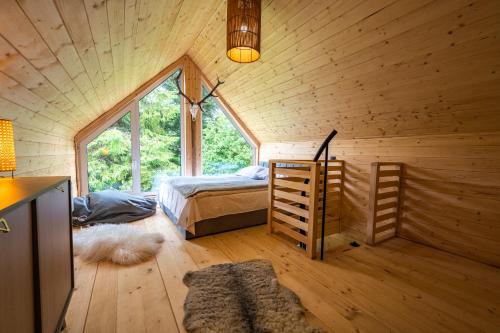 a bedroom with a bed in a wooden cabin at Rykowisko Korbielów 2 in Korbielów