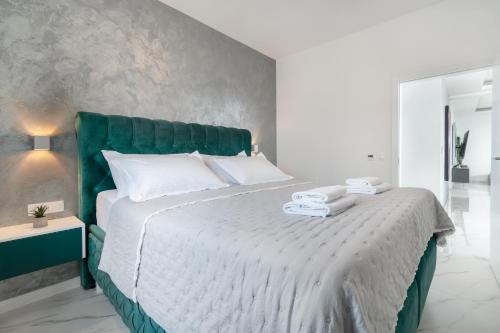 a bedroom with a large bed with a green headboard at Lux Penthouse Panoramic View with jacuzzi in Makarska