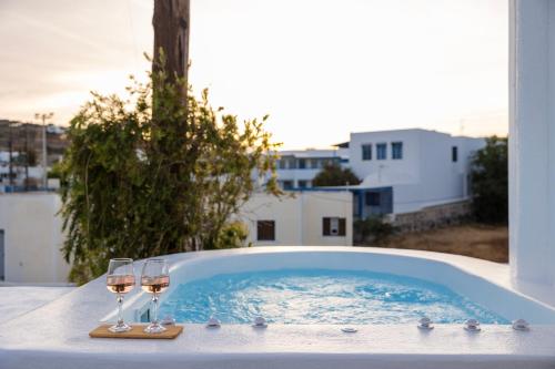 two glasses of wine sitting on a hot tub at Commercio Suites Santorini in Emporio Santorini