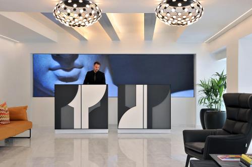 a man standing at a podium in a living room at The Athenaeum Luxury Hotel in Athens