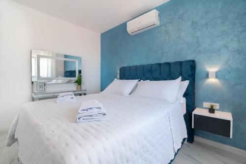 a bedroom with a large bed with a blue wall at Lux Penthouse Panoramic View with jacuzzi in Makarska