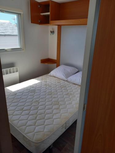 une petite chambre avec un lit dans une pièce dans l'établissement mobil home camping 3 etoiles les ollivaud, à La Baule