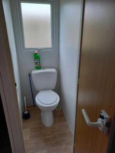 Elle comprend une petite salle de bains pourvue de toilettes et d'une fenêtre. dans l'établissement mobil home camping 3 etoiles les ollivaud, à La Baule