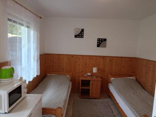 a small room with two beds and a microwave at Zielona Dolina in Łagów
