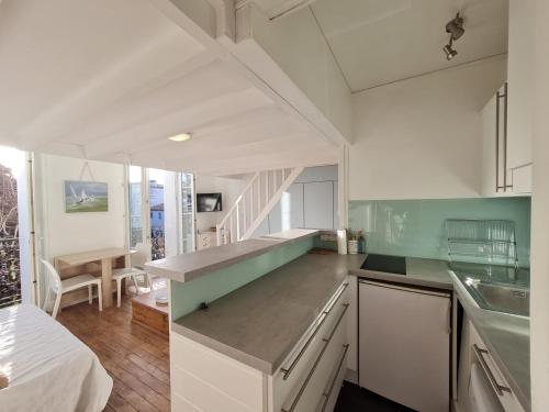 - une cuisine avec des placards blancs et des murs verts et blancs dans l'établissement STUDIO COSY 100 m DE LA PLAGE DE FONCILLON, à Royan