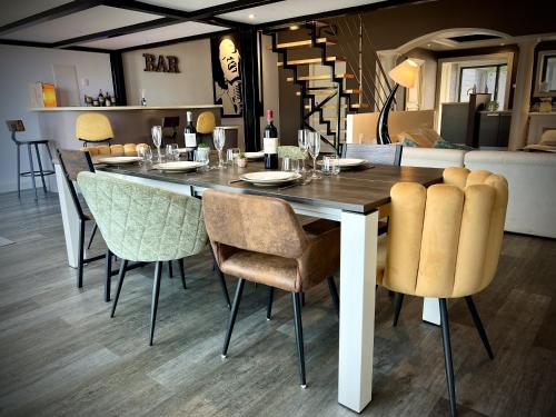 une table à manger avec des chaises et une salle à manger dans l'établissement Magnifique Loft 160m2 x 6 pers Proche plage, à Les Sables-dʼOlonne