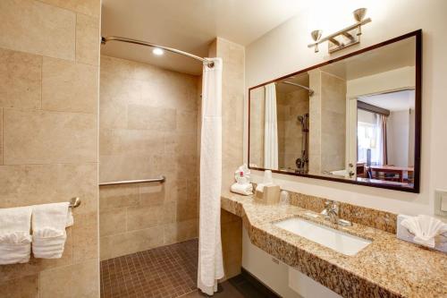 een badkamer met een wastafel en een spiegel bij Newport Channel Inn in Newport Beach