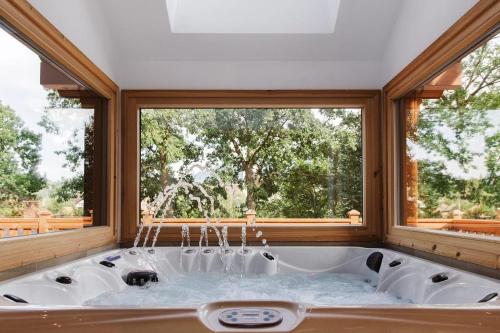 una vasca da bagno in una stanza con una grande finestra di Transylvania Mountain Chalet a Bran