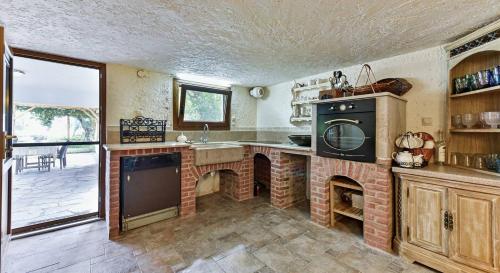 a kitchen with a brick oven and a sink at Azure Coast Seafront Retreat in Mola Kalyva