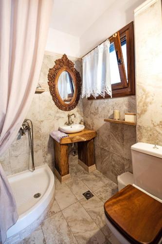 a bathroom with a sink and a toilet and a tub at Azure Coast Seafront Retreat in Mola Kalyva