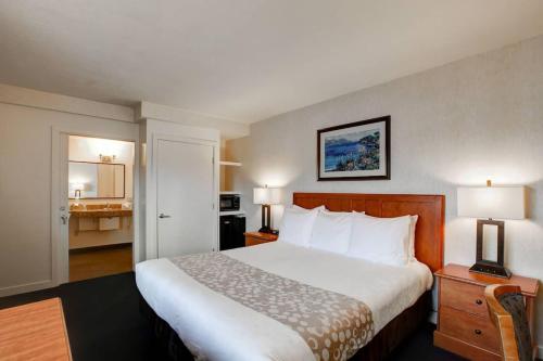 a hotel room with a large bed and a kitchen at Newport Channel Inn in Newport Beach