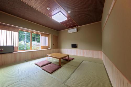 a room with a table and a window at Yumoto Onsen OharaSansou in Kyoto