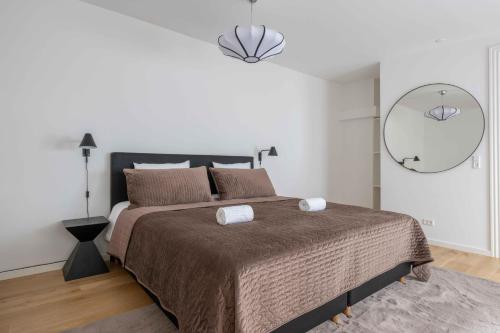 a bedroom with a large bed with two towels on it at Stylish Apartment on Lively Street in Downtown in Copenhagen