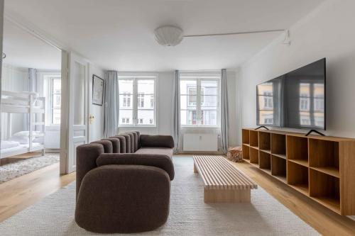 a living room with two couches and a flat screen tv at Stylish Apartment on Lively Street in Downtown in Copenhagen