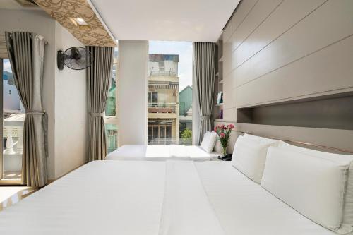 1 Schlafzimmer mit 2 Betten und einem großen Fenster in der Unterkunft Lucky Star Hotel Q5 in Ho-Chi-Minh-Stadt