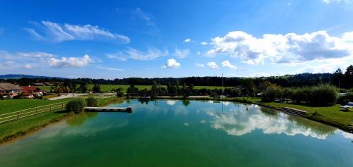 a river with a boat in the middle of it at Terrassen-Camping am Richterbichl in Rottenbuch