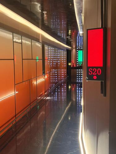 an empty hallway with a red sign on a wall at Shanghai Maybeours Hotel in Fengxian