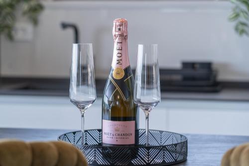 a bottle of champagne and two wine glasses on a table at Lux Penthouse Panoramic View with jacuzzi in Makarska