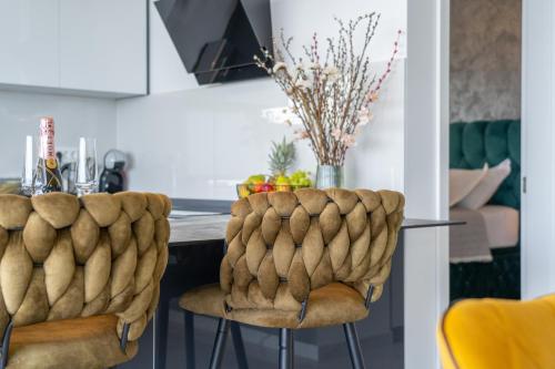 a kitchen with a table and two yellow chairs at Lux Penthouse Panoramic View with jacuzzi in Makarska