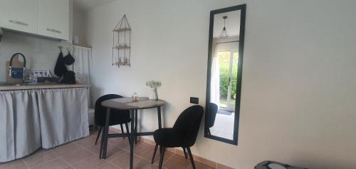 Eleonora's apartment في أولبيا: مطبخ مع طاولة وكراسي ومرآة