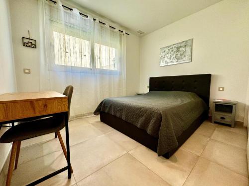 1 dormitorio con cama, escritorio y ventana en Apartamento de lujo cerca de Benidorm, en Alicante