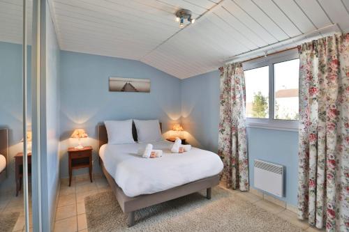 une chambre avec un lit blanc et une fenêtre dans l'établissement Maison authentique avec jardin, à Les Sables-dʼOlonne
