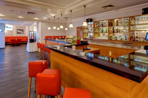 a bar in a restaurant with orange chairs at Best Western Ahorn Hotel Oberwiesenthal – Adults Only in Kurort Oberwiesenthal