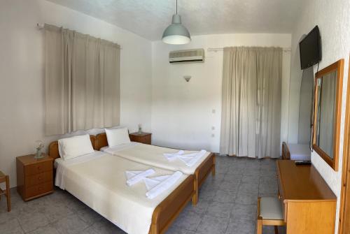 una camera da letto con un letto e due asciugamani di Marigoula Village a Skopelos Town