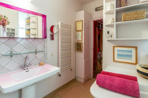 une salle de bain avec un lavabo et un miroir dans l'établissement Géranimus Enghien, à Paris
