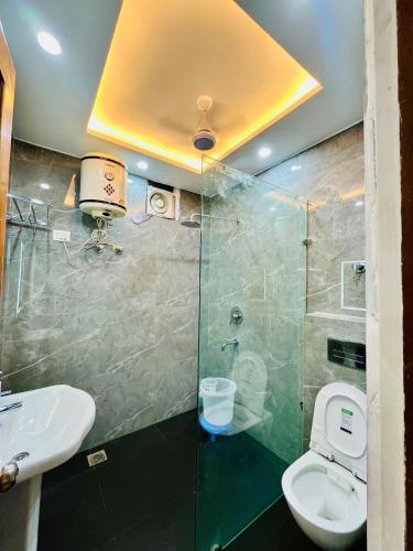 a bathroom with a shower and a toilet and a sink at Hotel Park Hills in Jammu