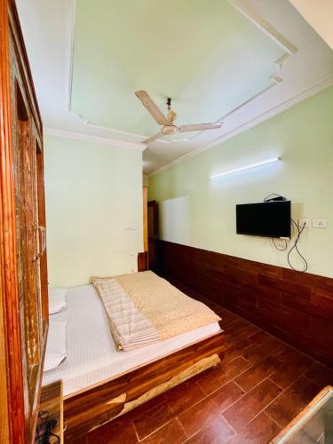 a room with a bed and a tv on the wall at Hotel Park Hills in Jammu