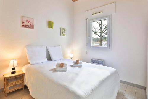 - une chambre avec un grand lit blanc et 2 boîtes dans l'établissement Appartement confortable, 300m plage du Veillon, à Talmont-Saint-Hilaire