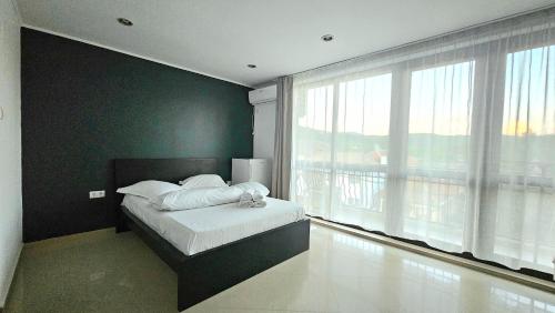 a bedroom with a bed and a large window at Yes Home in Călimăneşti