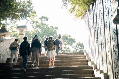a group of people walking up some stairs at Kotori Coworking & Hostel Kotohira in Kotohira