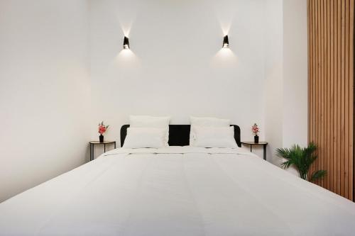 - une chambre blanche avec un grand lit blanc et des oreillers blancs dans l'établissement Sublime 2 Bedroom Flat in Paris, à Paris