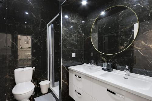 une salle de bain avec toilettes, lavabo et miroir dans l'établissement Sublime 2 Bedroom Flat in Paris, à Paris