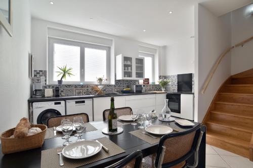 une salle à manger avec une table et des chaises et une cuisine dans l'établissement Les Myosotis du Val - Duplex à quelques pas de la mer, à Pléneuf-Val-André