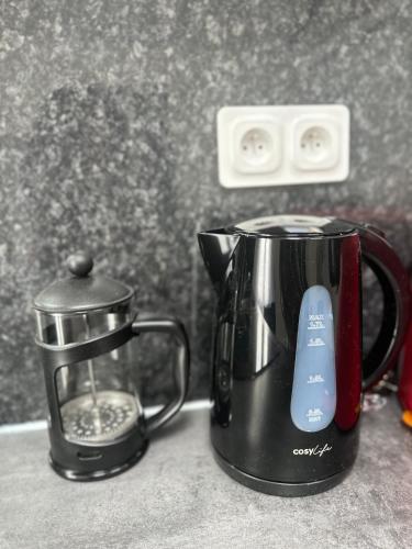 a black coffee maker sitting on top of a counter at Cosy Home Stade de france in Aubervilliers