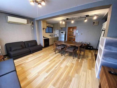 a living room with a table and a couch at New飯田橋ファミリーホテル in Tokyo