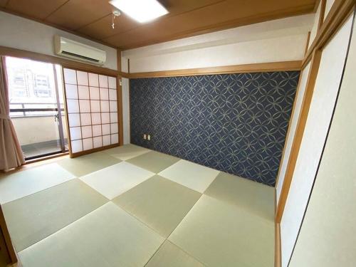 an empty room with a tiled floor and a window at New飯田橋ファミリーホテル in Tokyo