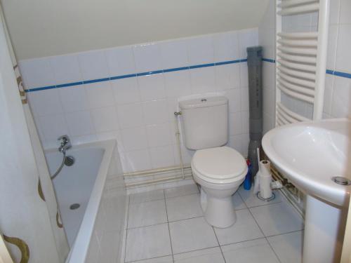 une salle de bain blanche avec des toilettes et un lavabo dans l'établissement Petit Argousier, à Cambron