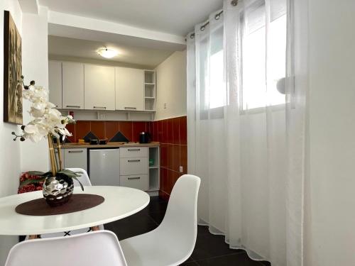 a kitchen with a white table and white chairs at Apartments Pribilovic in Budva