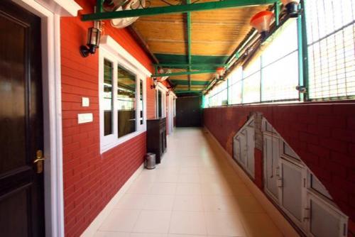 an empty hallway of a building with red brick walls at Hotel Park Hills in Jammu