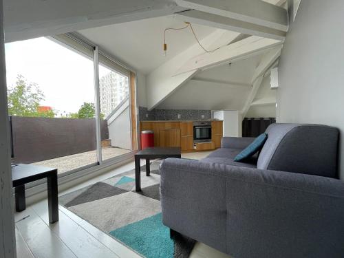 un salon avec un canapé et une grande fenêtre dans l'établissement Residence St Jacques, à Clermont-Ferrand