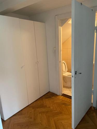 a room with white cabinets and a bathroom with a toilet at Astay in Malmö